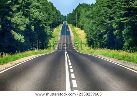 A long straight asphalt roadway on a hill. Royalty-Free Stock Photo #2358259605