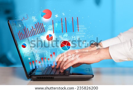Hand typing on modern laptop notebook computer with future graph icons and symbols 