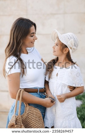 Little girl kiss her mom. Happy daughter spend time with mother. Stylish family