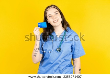 Close up photo of optimistic Young caucasian doctor woman wearing blue uniform hold card