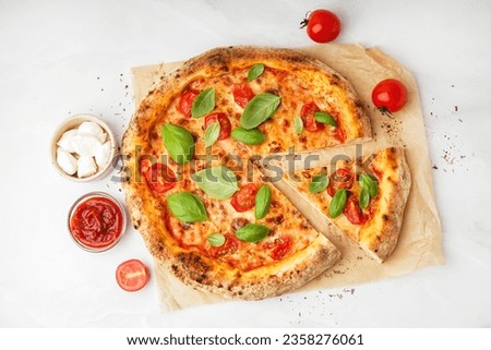 Baking paper with tasty pizza Margarita and basil on white background