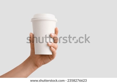 Woman with takeaway cup of hot coffee on white background Royalty-Free Stock Photo #2358276623