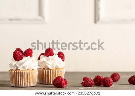 Tasty raspberry cupcakes on table Royalty-Free Stock Photo #2358276691