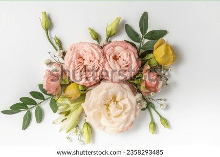 floral layout of pink roses on a soft blue background. Top view.