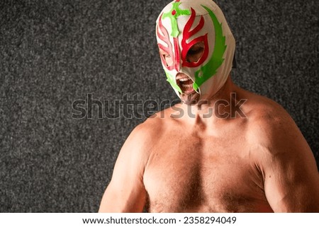 Lucha masked man showing emotion, dark background, copy space image