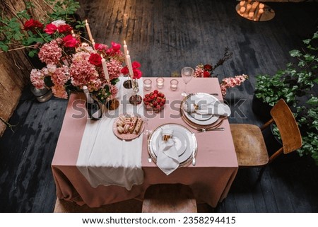 Candlelight dinner setup for couple on Valentines day. Decoration flowers, decor candles, details closeup. Romantic date. Location for surprise marriage proposal. Table setting in restaurant. Top view Royalty-Free Stock Photo #2358294415