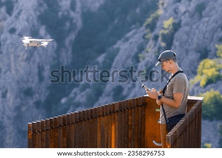 A young male flying by drone in the mountains. Aerial photography. Drone control. Observation point near Gubavica waterfall in Croatia.