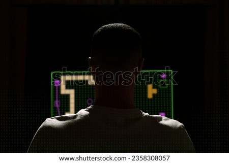 Gaming disorder. Man playing on computer in darkness, back view