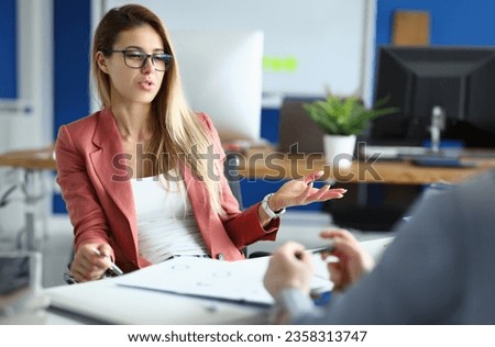 Businesswoman in office communicates with colleague at work. Royalty-Free Stock Photo #2358313747