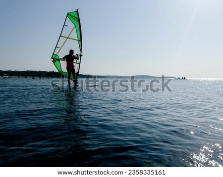 Recreational Water Sports. Windsurfing. Windsurfer Surfing The Wind On Waves In Ocean, Sea. Extreme Sport Action. Summer Fun Adventure. . High quality photo