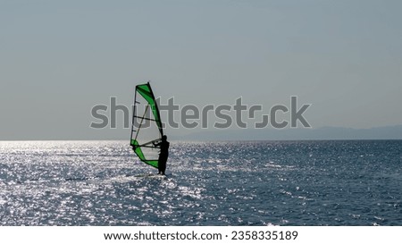 Recreational Water Sports. Windsurfing. Windsurfer Surfing The Wind On Waves In Ocean, Sea. Extreme Sport Action. Summer Fun Adventure. . High quality photo