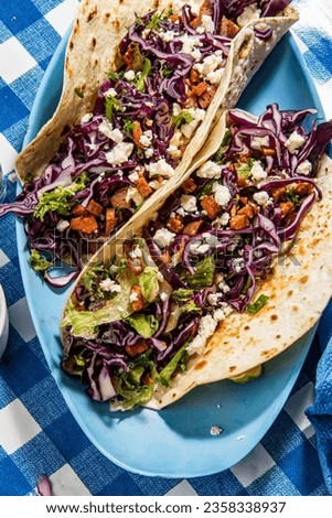 Tacos with roasted chiken with cabbage, salad, feta cheese and sauce