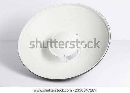 Close up on a potographic beauty dish with grid, background is white.