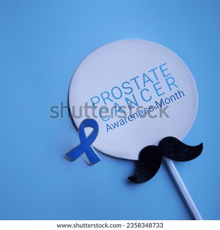 Mustache and blue ribbon with text PROSTATE CANCER AWARENESS MONTH. Medical and healthcare concept