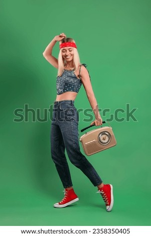 Happy hippie woman with retro radio receiver on green background
