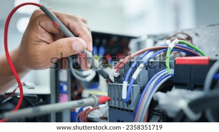 Electrical engineer checking and fixing automatic control switchboard to resume normal operation, industrial technology work concept and work safety.