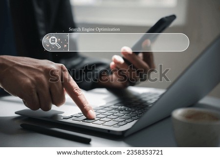 A businessman's hand is using a laptop to search and browse the internet for information. The concept of search engine optimization and networking is highlighted by the blank search bar.
