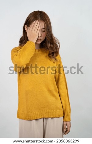 Excited Asian woman raising hands gesture on isolated background, promo advertisement concept Cheerful teenage girl in yellow shirt standing in white room