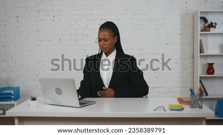 Modern businesswoman creative concept. Woman at the desk working on laptop, feeling hungry, touching her stomach area.