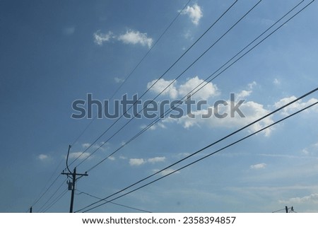 Powerlines on a blue sky day Royalty-Free Stock Photo #2358394857