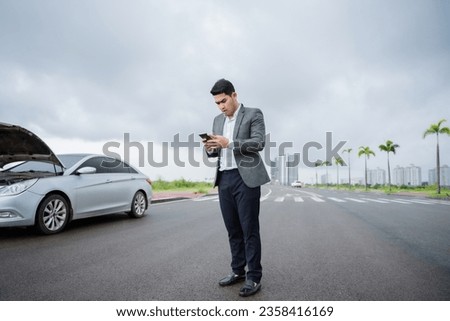 Angry asian man Stand front a broken car calling for assistance Royalty-Free Stock Photo #2358416169