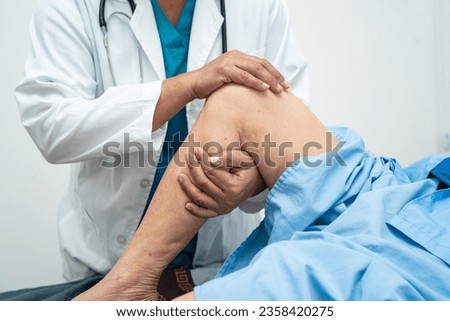 Asian elderly woman patient show her scars surgical total knee joint replacement Suture wound surgery arthroplasty on bed in nursing hospital ward, healthy strong medical concept. Royalty-Free Stock Photo #2358420275