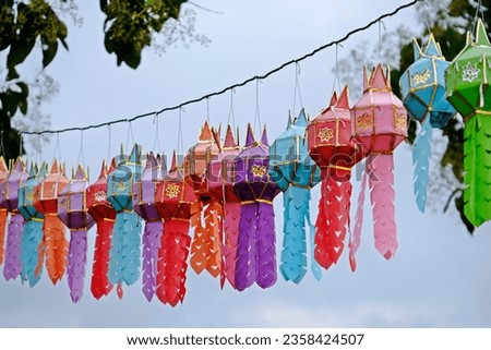 Lanna lantern (Yi Peng lantern), colourful traditional handmade Thai lamps in northern style hanging on the rope in temple. Royalty-Free Stock Photo #2358424507