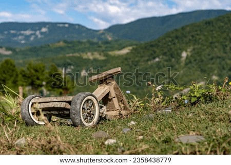 Old broken diy wooden bike toy in mountains Royalty-Free Stock Photo #2358438779