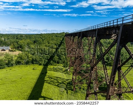 An aerial view of the Moodna Viaduct, a steel railroad trestle spanning Moodna Creek and its valley at the north end of Schunemunk Mountain in Cornwall, New York. Taken with a drone on a sunny day.