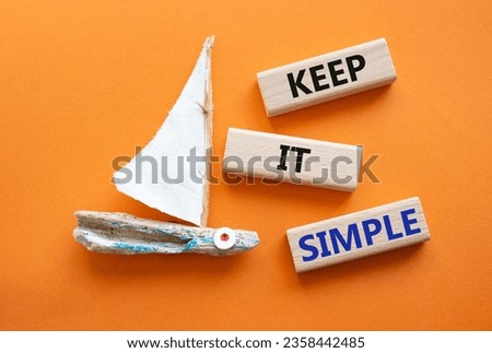 Keep it Simple symbol. Concept words Keep it Simple on wooden blocks. Beautiful orange background with boat. Business and Keep it Simple concept. Copy space.