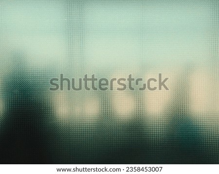 A blurry silhouette of people pass being photographed from a mozaik glass of window.