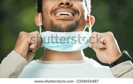 Mouth, mask and remove with a man breathing fresh air in nature, feeling happy at the end of restrictions. Covid, freedom and post lockdown with a person closeup in the forest, woods or wilderness Royalty-Free Stock Photo #2358456487
