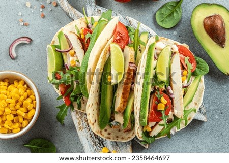 Healthy corn tortillas with grilled chicken, avocado, fresh tomatoes, limes. place for text, top view. Royalty-Free Stock Photo #2358464697