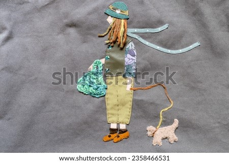 handmade image of girl with dog appliqued on gray fabric close up