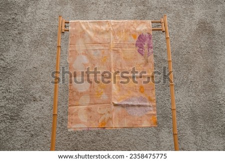 Traditional Javanese batik cloth with fine details hung on rattan hangers. These batik cloth sheets are hand drawn by professional craftsmen with various motifs and bright colors