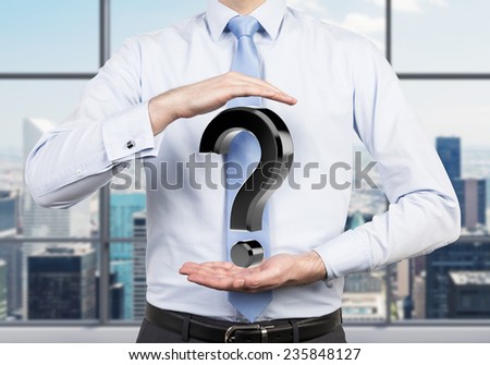 businessman holding black question mark, close up