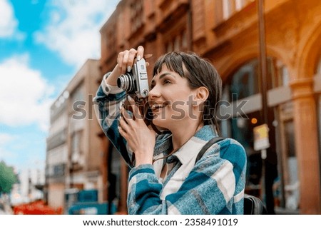 woman in blue shirt and cap with backpack  walking around  city, taking photos, selfie, having fun as tourist Lifestyle concept Royalty-Free Stock Photo #2358491019
