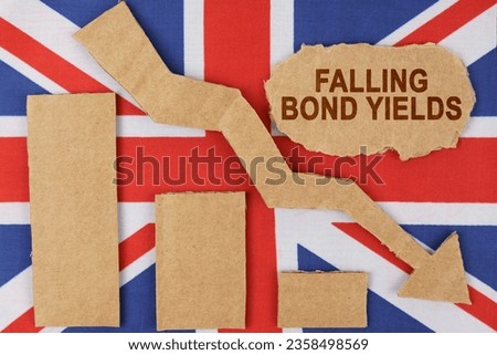 Economy and finance concept. On the flag of Great Britain there is a diagram cut out of cardboard, an arrow down and a sign with the inscription - falling bond yields.
