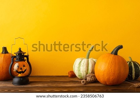 Autumnal fright fest. Side view photo of autumn vegetables, including pumpkins, pattypans, walnut, physalis, spine-tingling jack o' lantern, set against orange backdrop with space for eerie message