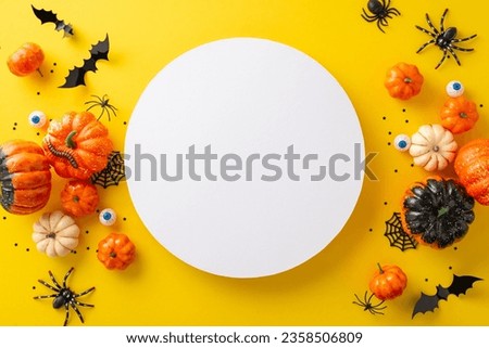 Celebration of spooky Halloween night concept. Top-view photo of pumpkins, spiders, human eyes and other Halloween decorations on yellow isolated background with copy-space for advertising or text