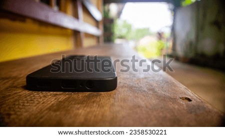 black smartphone on wooden stool
