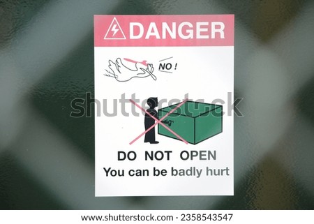danger do not open you can be badly hurt with illustration picture shot through fence, white red green black