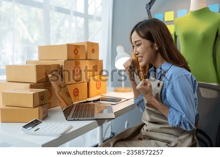 Small business startup, SME owner, female entrepreneur working on packaging parcel boxes, showing happy expression. business success Good feedback from customers independent business idea.