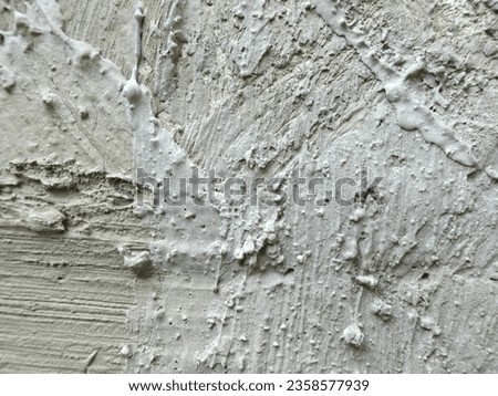 An grey abstract pattern formed from plastering a wall with cement. 