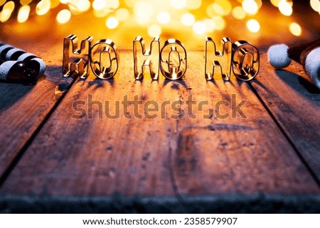 Ho Ho Ho on old wood and defocused gold lights - Christma