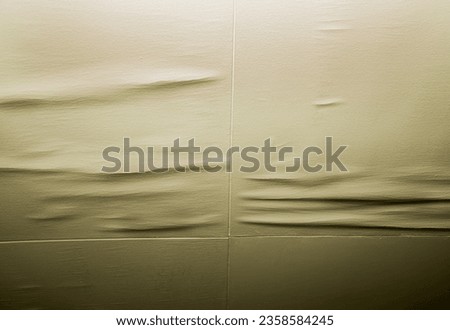 Isolated shot of soiled water damaged ceiling panels with cracks at seams.  