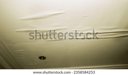 Isolated shot of soiled water damaged ceiling panels with cracks at seams.  