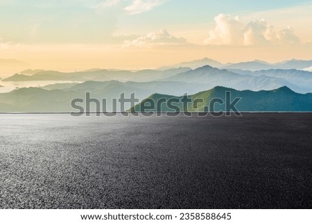 Asphalt road and mountain range natural scenery at sunrise