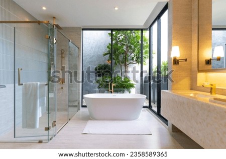 Modern White Bathroom Design with Freestanding Bathtub. Light shine through from aside. Royalty-Free Stock Photo #2358589365