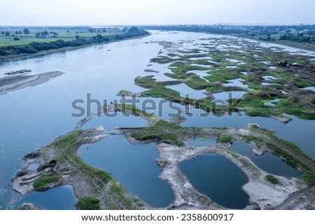 Aerial footage of the River Bhima and surrounding landscape including bridges at Daund India. Royalty-Free Stock Photo #2358600917